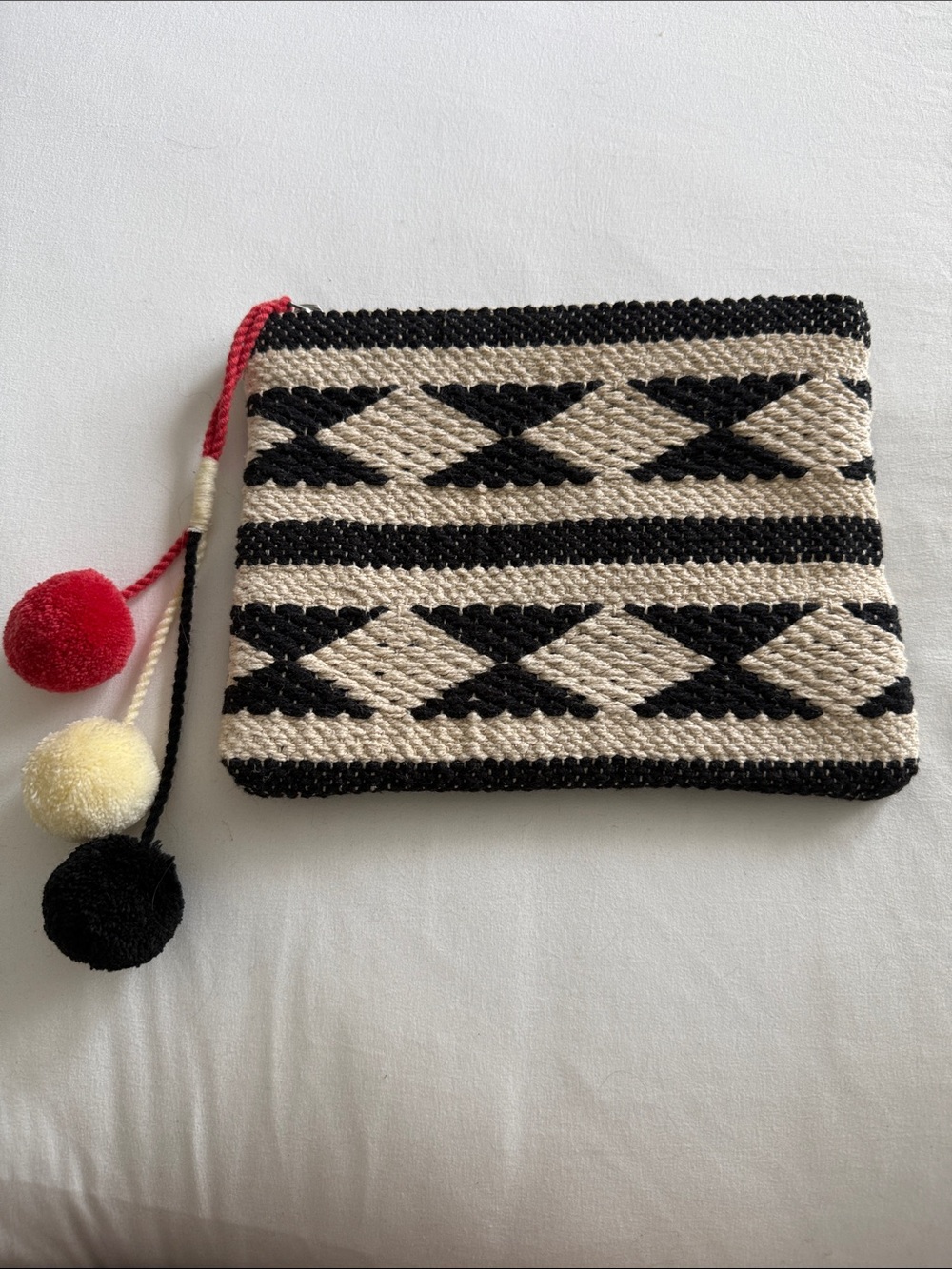 Handwoven Black and Cream Geometric Clutch with Pom Pom Accents